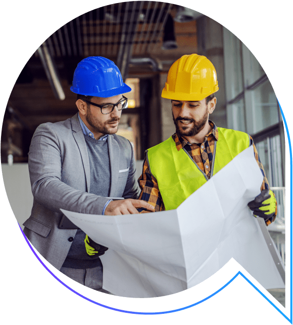Two construction professionals reviewing blueprints, wearing hard hats and safety vests.
