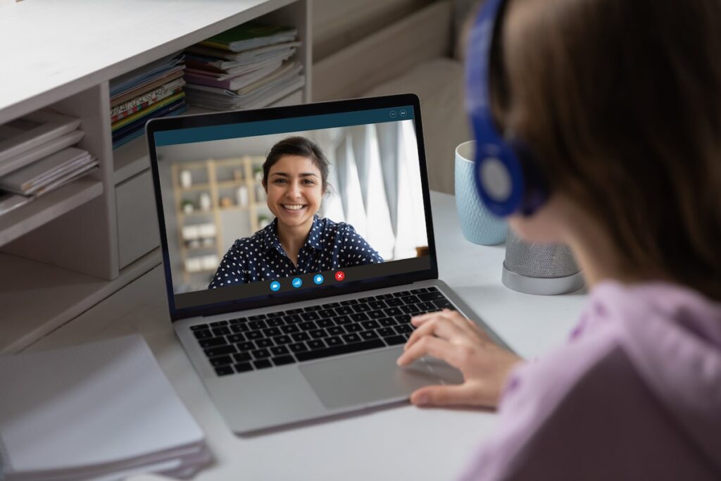 Woman having a video conference with her virtual assistant through  a laptop.