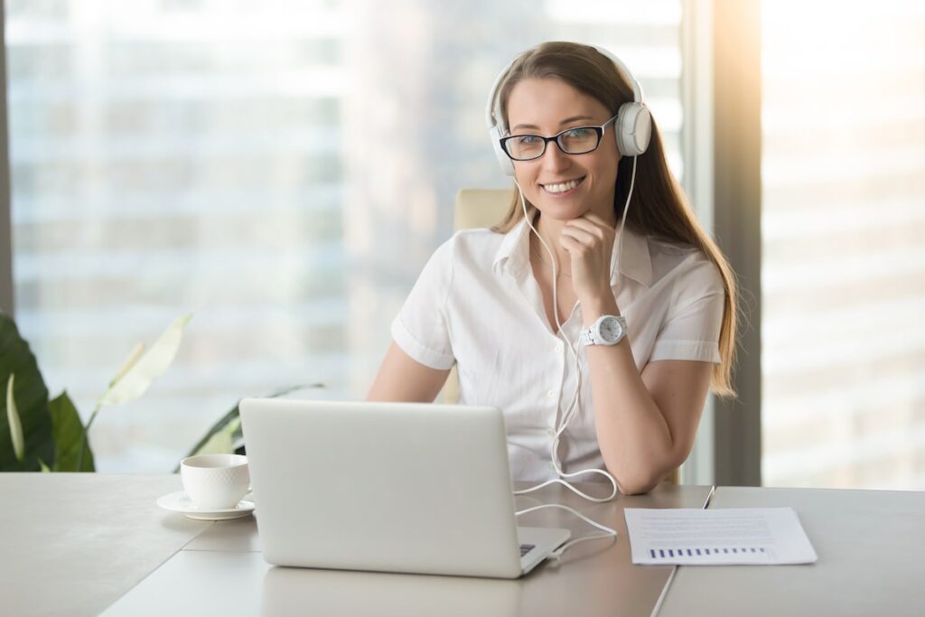 Smiling virtual assistant working on laptop.