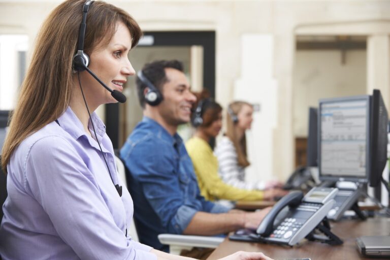 Call center team using headsets, working at computers.