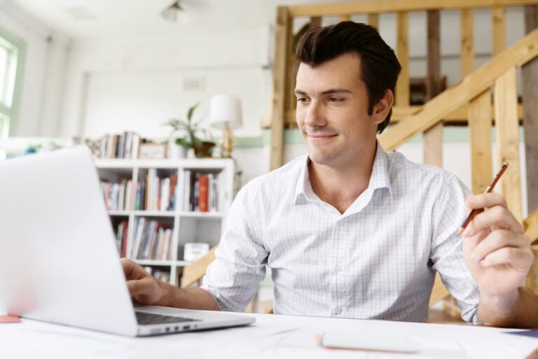 Person working remotely on a laptop in a modern home office setting.