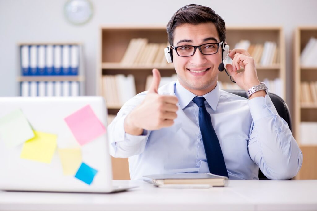 Happy man who works as phone operator doing outsource sales for a business owner.