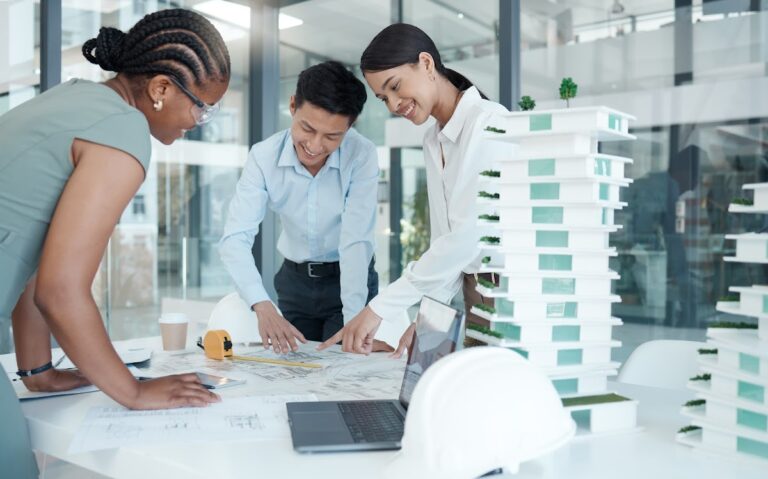 Architects collaborating on a construction project with blueprints and models in a modern office.