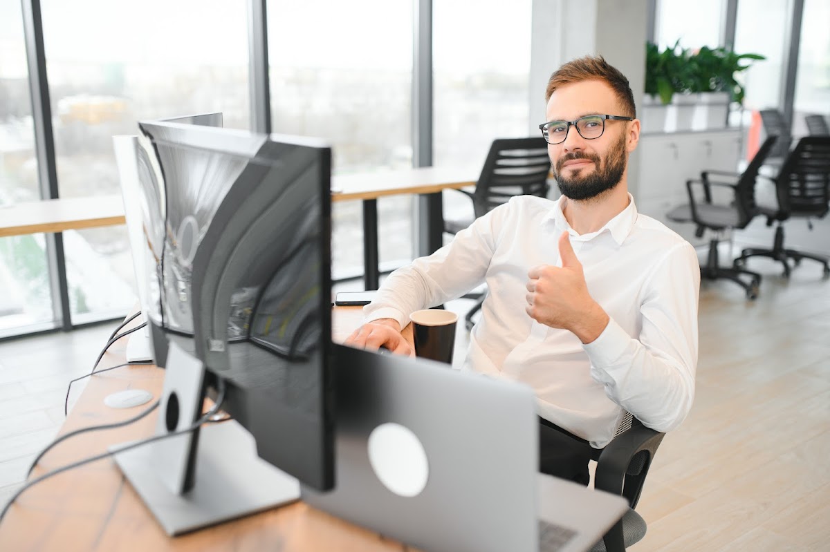 Professional working on multiple screens in a modern office setting.