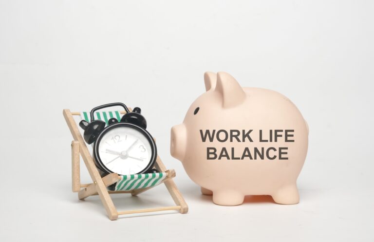 Alarm clock on chair beside work life balance piggy bank
