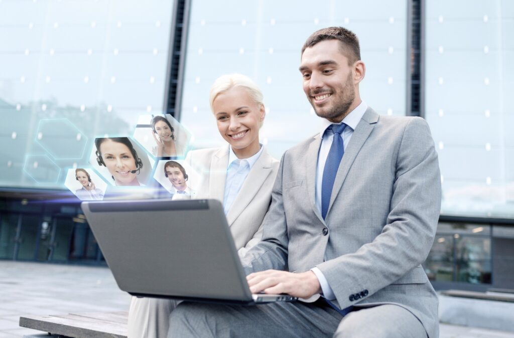 Business professionals using laptop with digital profiles