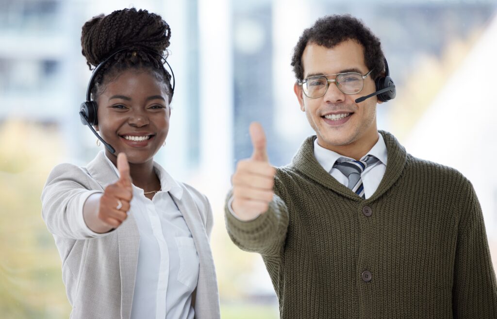 Customer service agents smiling thumbs up