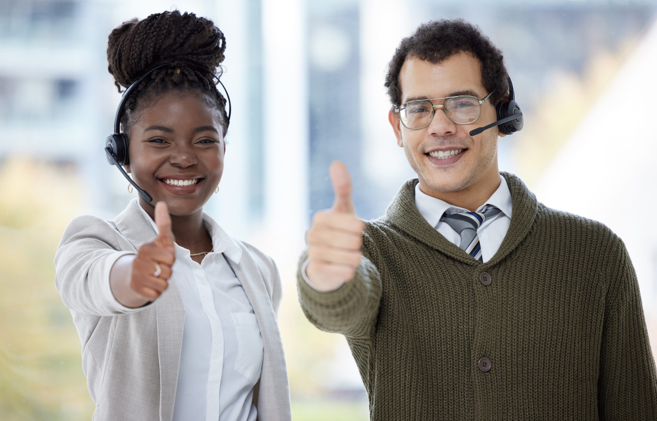 Customer service agents smiling thumbs up