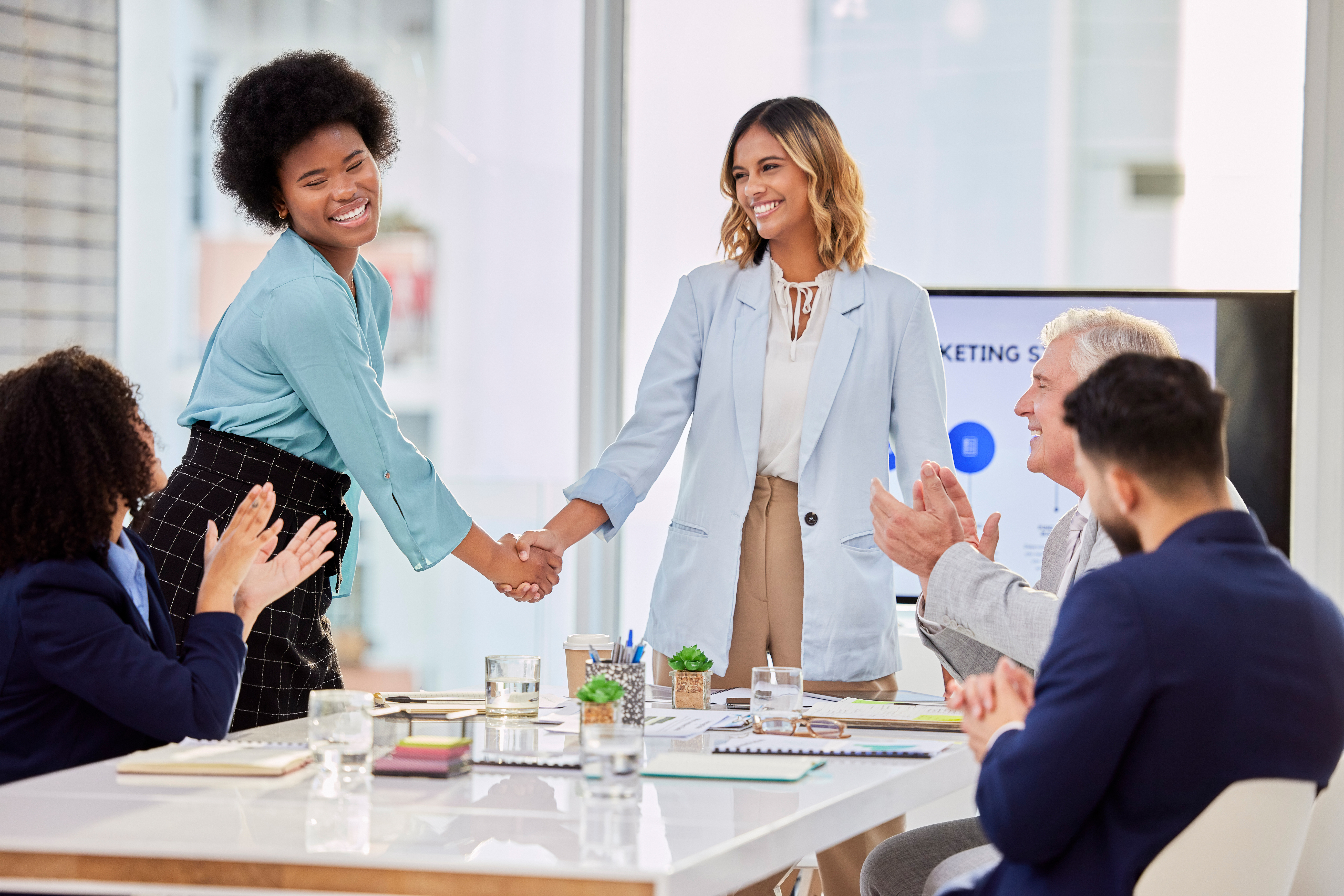 Businesswomen shaking hands in office meeting