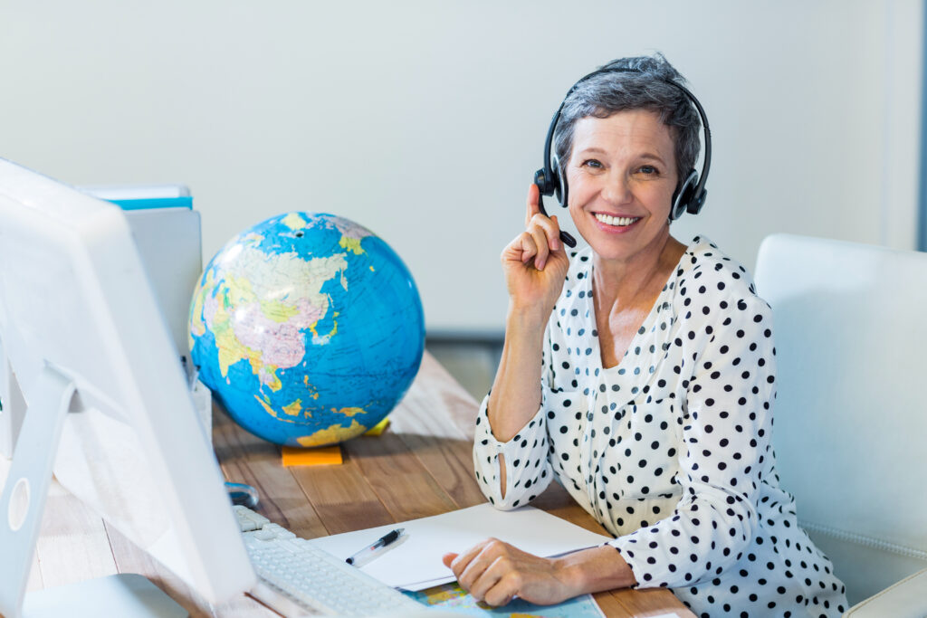 Woman with headset at desk and globe