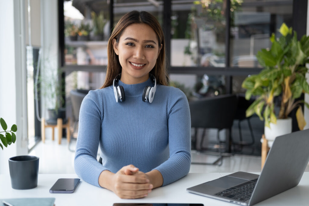 Woman smiling with headphones at desk