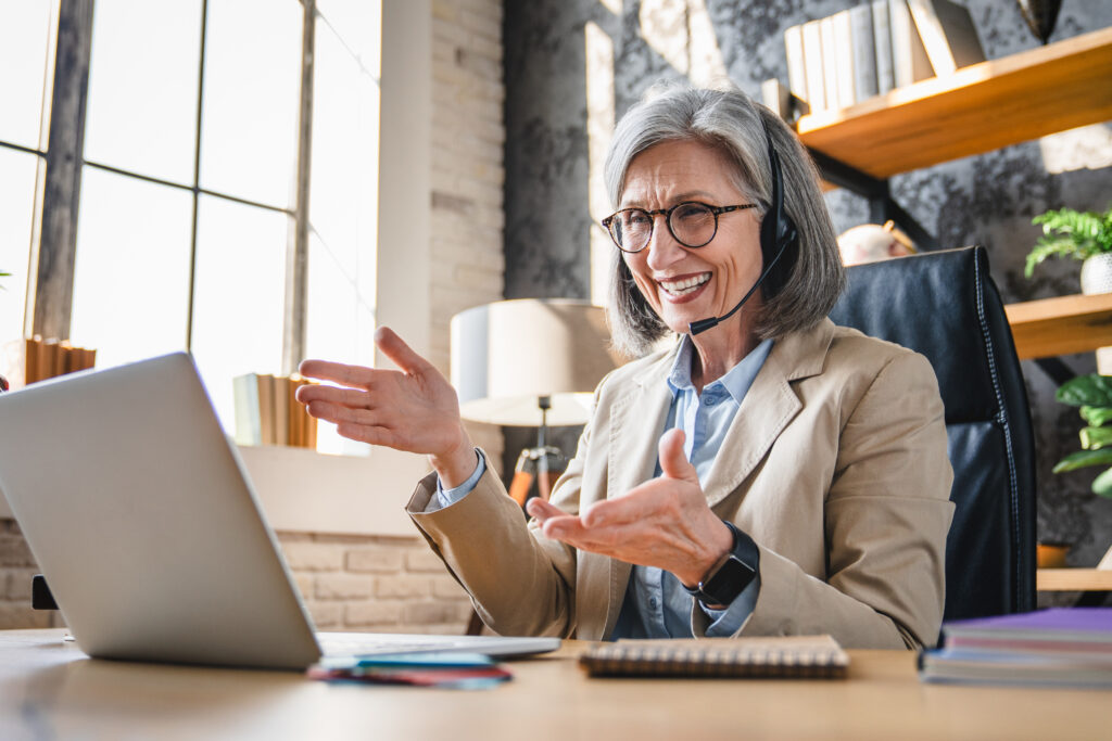 Senior woman video calling with headset
